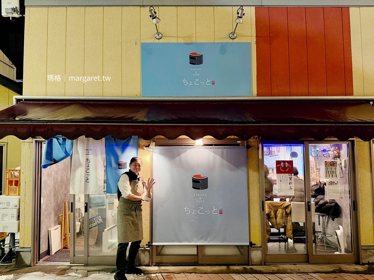 青森魚酒小館主廚在店門口拍照。