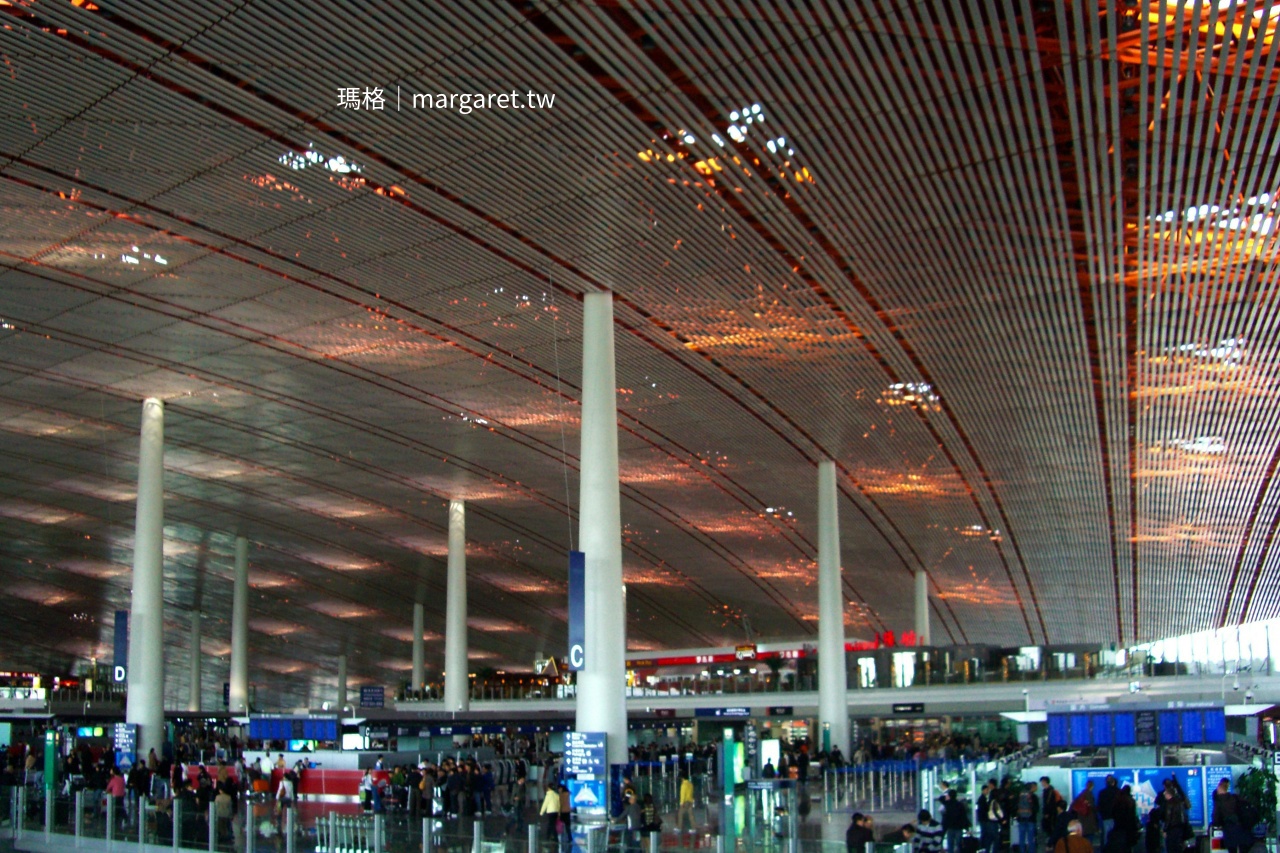 北京機場現代建築室內空間，旅客往來熙攘。