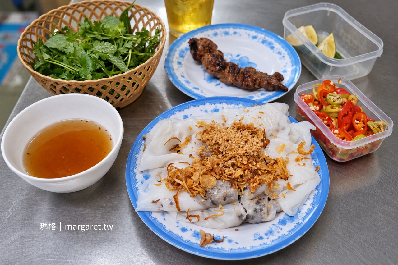 河內 Tuệ An 招牌熱蒸米皮捲，米皮上撒有炸紅蔥頭，搭配魚露沾醬、香草、辣椒與烤豬肉串