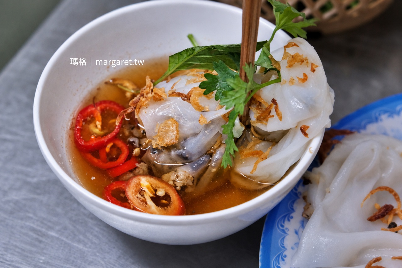 河內 Tuệ An 蒸米皮捲吃法，夾起米皮捲浸入魚露沾醬，搭配炸紅蔥頭、香草與紅辣椒