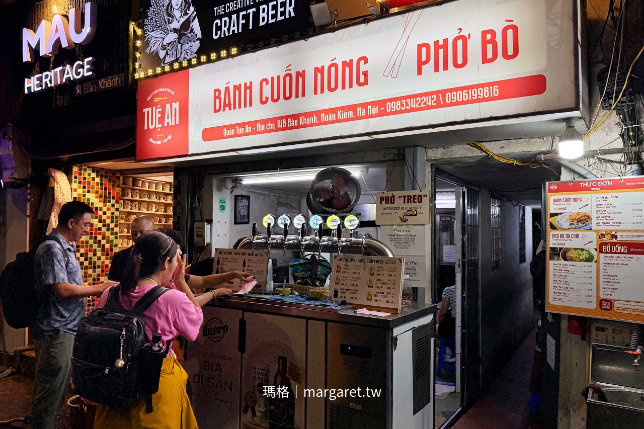 河內還劍湖附近 Tuệ An 蒸米皮捲與牛肉河粉店面，前方設有生啤酒設備，蒸米皮捲製作區位於吧台後方