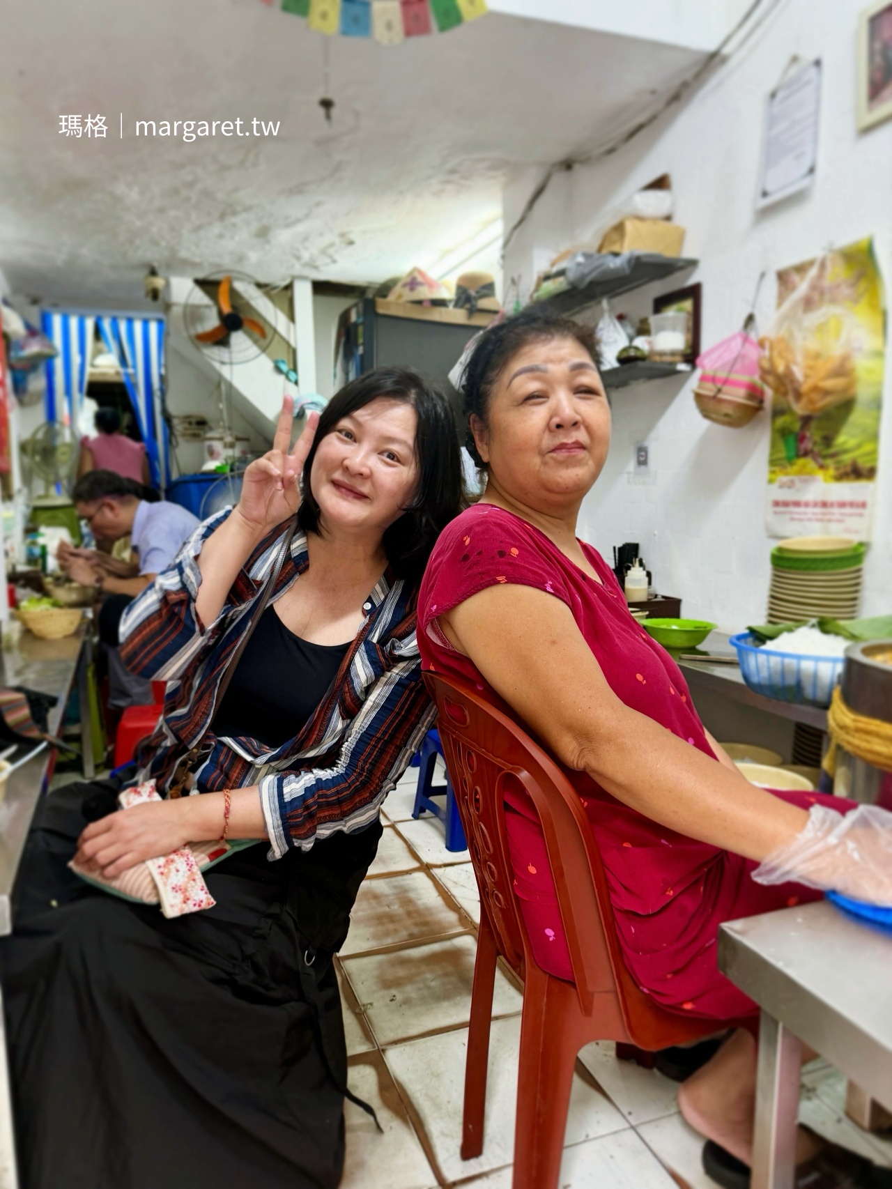 旅遊作家瑪格與河內 Bún Riêu - Hàng Bạc 米線攤老闆娘背對背靠著椅背溫馨合照