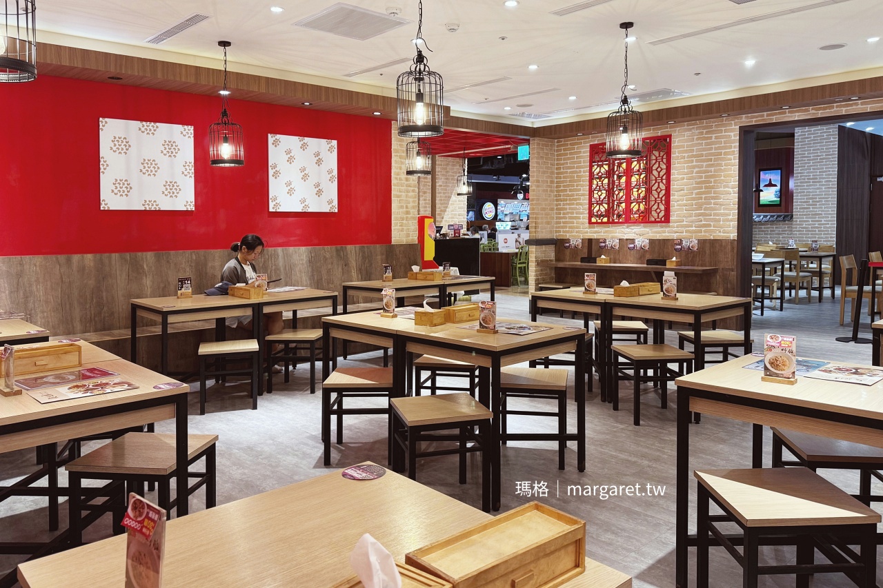 段純貞牛肉麵信義威秀店內用餐環境，木桌椅與中式窗花裝潢。