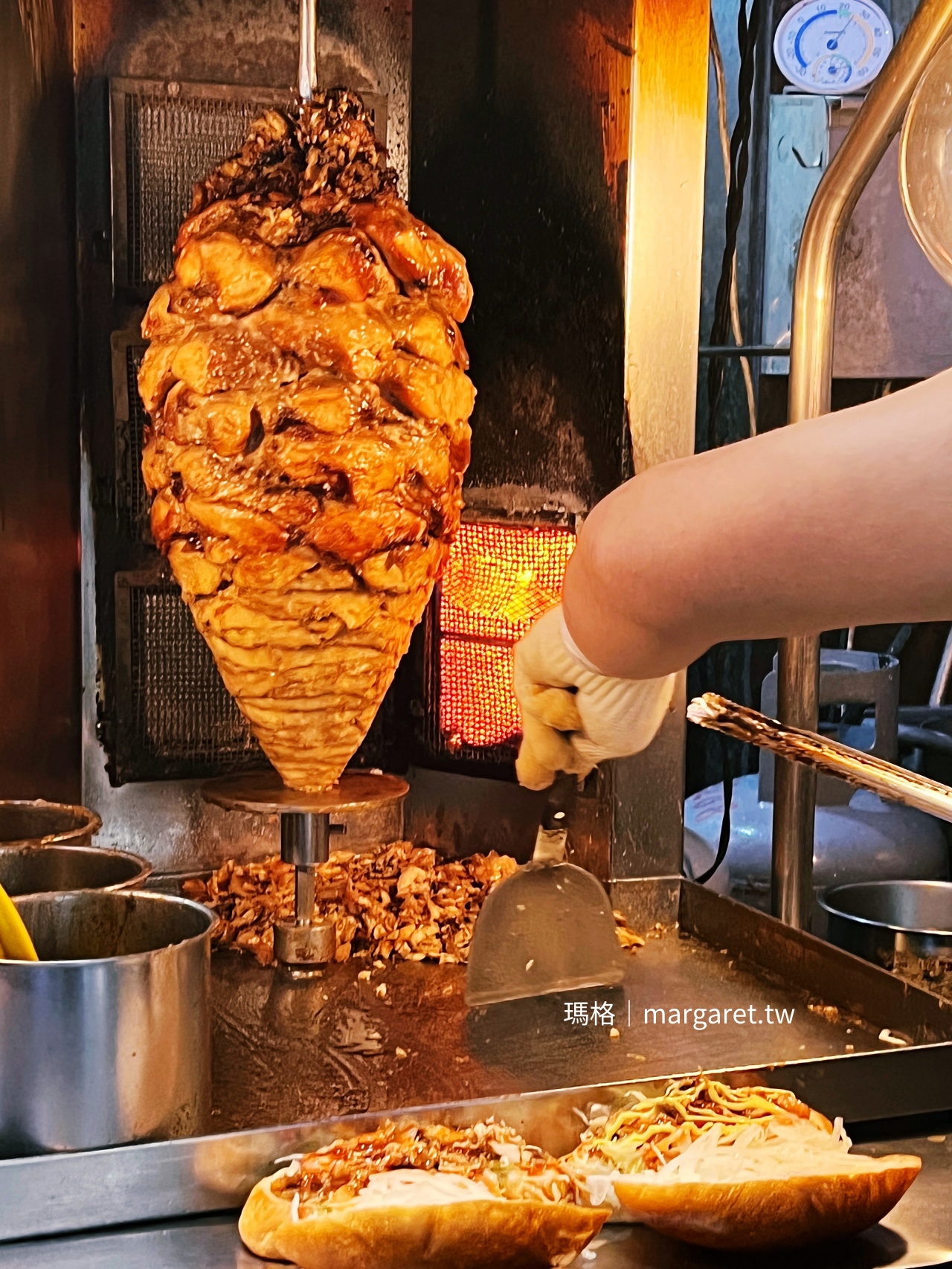 品盈沙威瑪旋轉烤肉串在烤燈前慢烤金黃，老闆邊刷醬邊削肉的現烤過程。