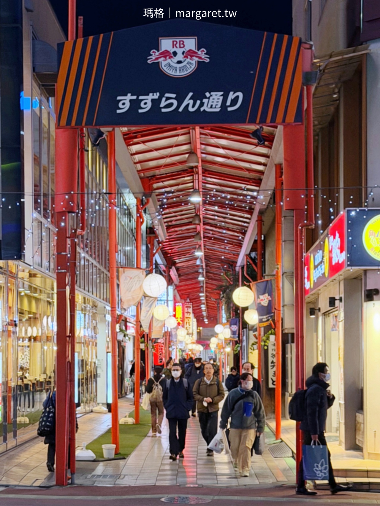 大宮鈴蘭通商店街（すずらん通り）入口夜景，拱形屋頂下掛有Omiya Ardija大宮松鼠足球隊隊徽。