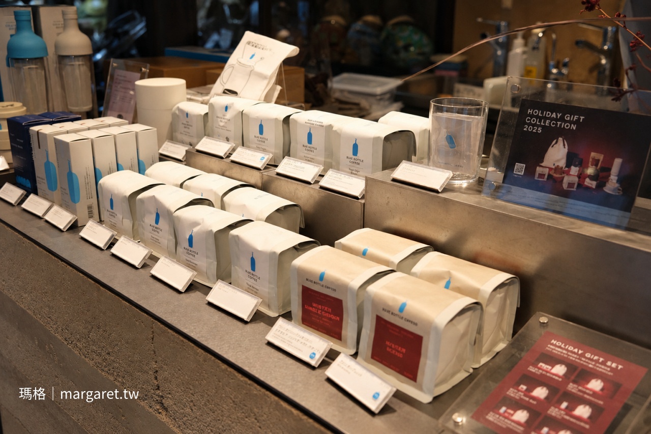 京都 Blue Bottle Coffee 六角店一樓商品展示櫃，陳列品牌咖啡豆、沖煮器具、玻璃杯與咖啡周邊商品