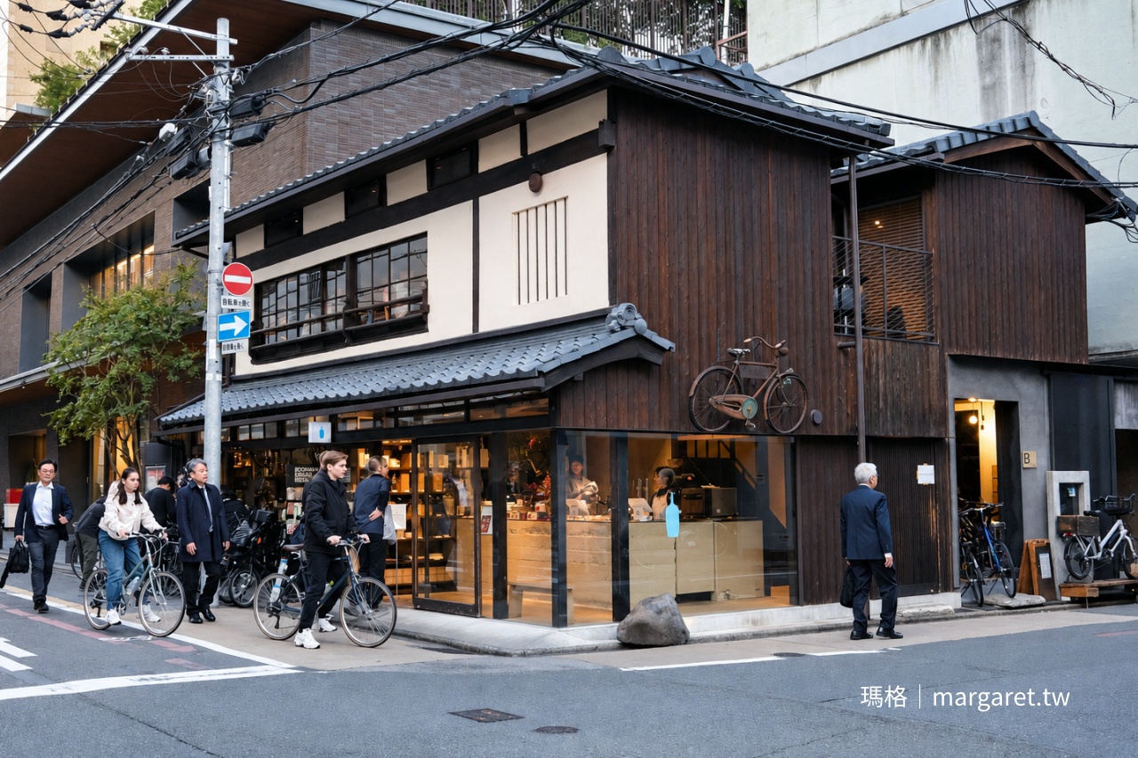 京都 Blue Bottle Coffee 六角店外觀，百年町家木造建築結合咖啡館與自行車店，街道上行人與單車交錯