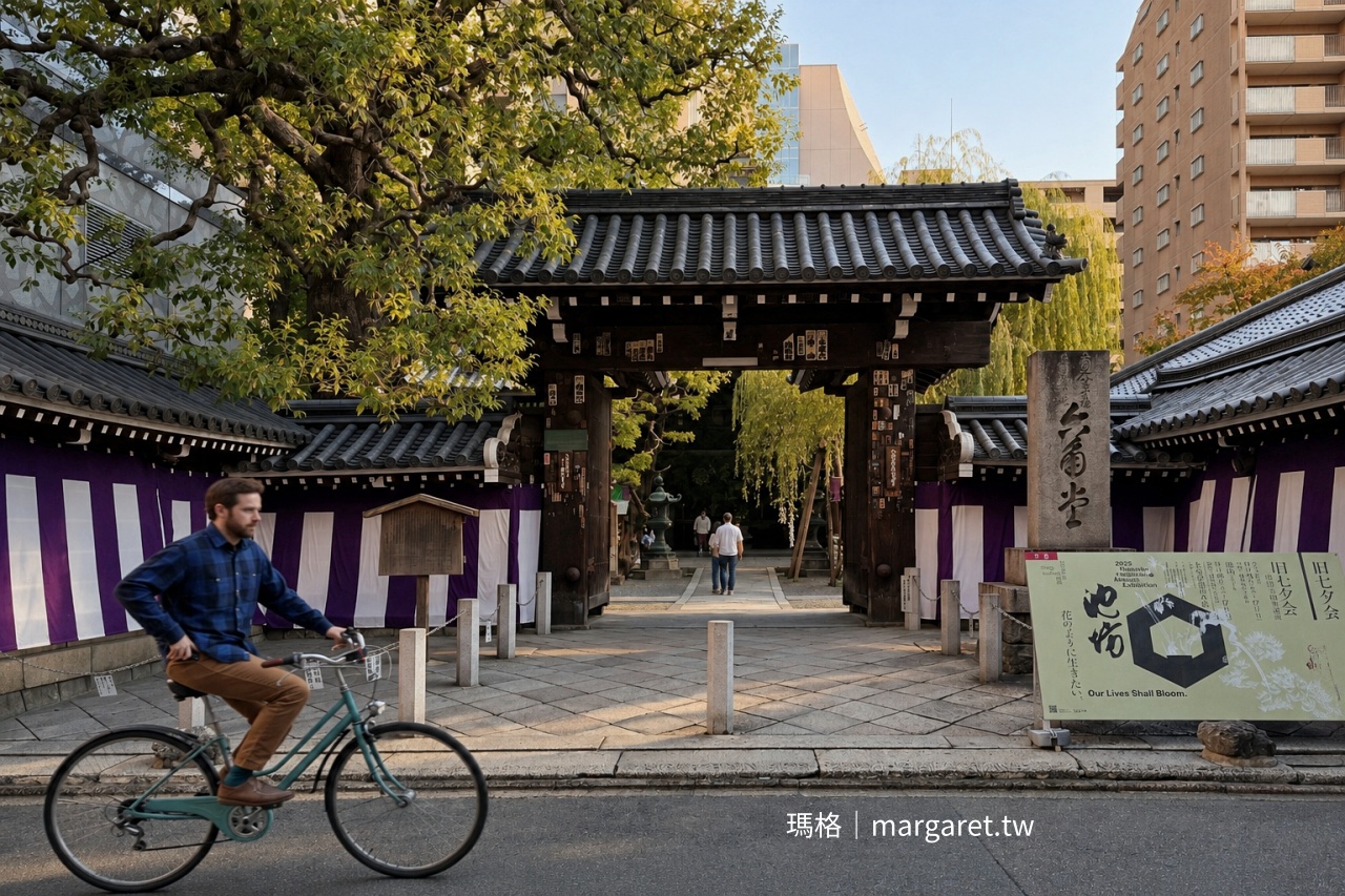 京都六角堂木造大門與瓦屋頂外觀，一名騎士騎自行車從寺門前經過