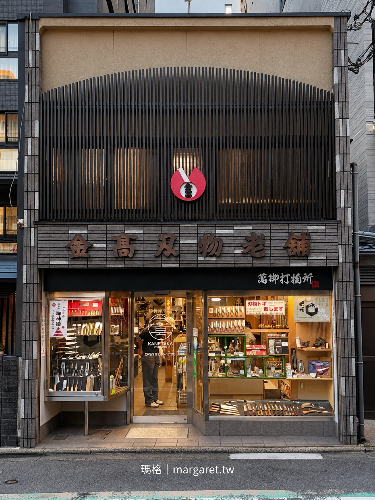 京都烏丸六角金高刃物老舖外觀，店面櫥窗陳列各式日本刀具，黑色格柵與紅色圓形標誌構成醒目的街角景觀