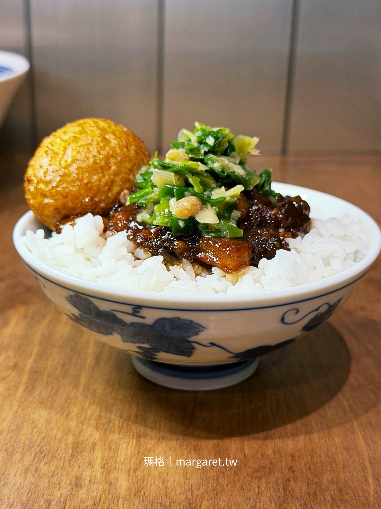 開囍滷肉專賣店黑金滷肉飯特寫，白飯上鋪著深褐色滷肉，搭配蔥油、柴魚與香菜