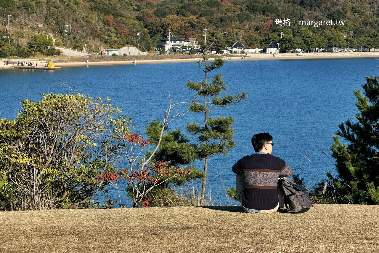隊長坐在山丘草地上背對鏡頭遠眺海岸與對岸黃南瓜致敬