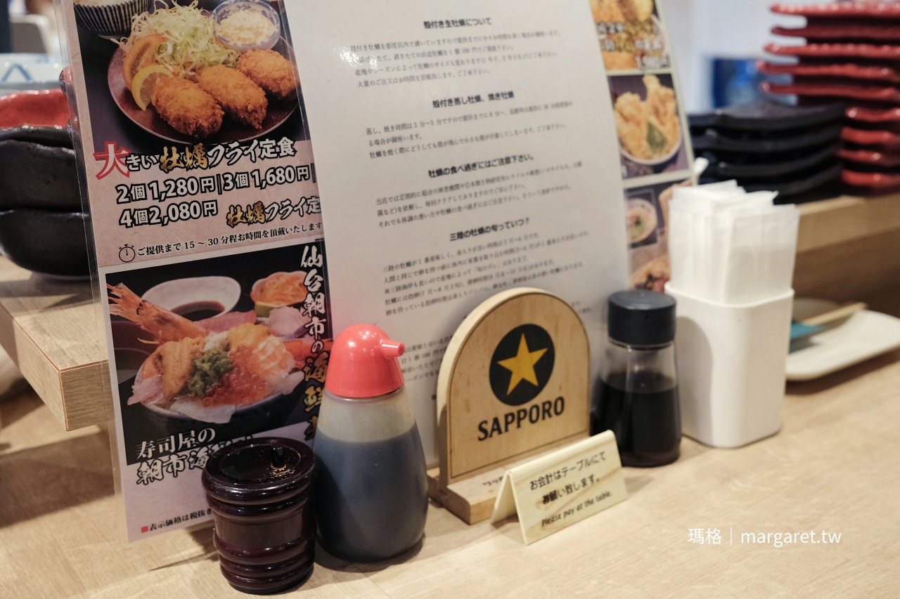牡蠣與壽司うみのおきて仙台朝市店，桌上的菜單、調味料與牡蠣產季說明。