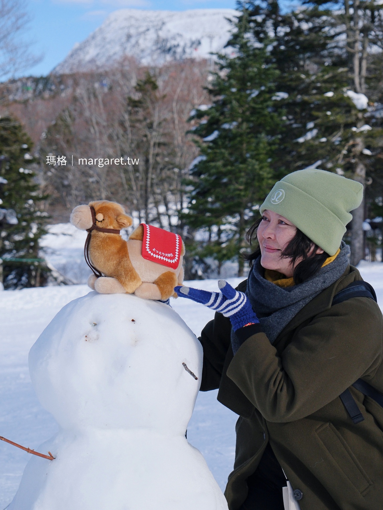 瑪格與鳥取駱駝玩偶在雪地合影。
